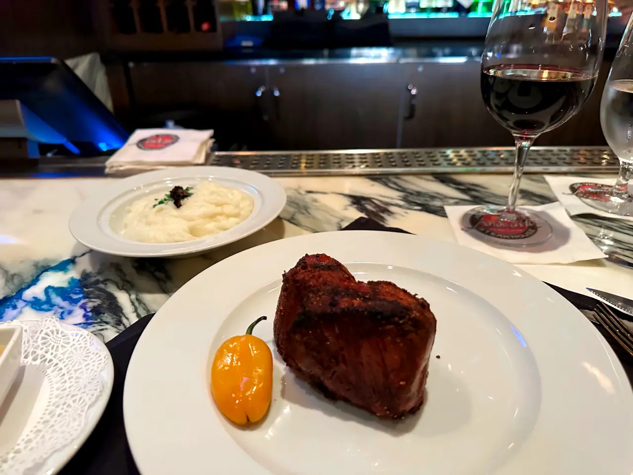 Photo of a steak, whipped potatoes, and wine