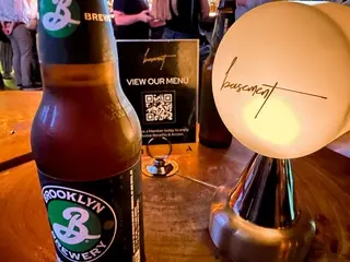 Photo of a drink and the basement table sign