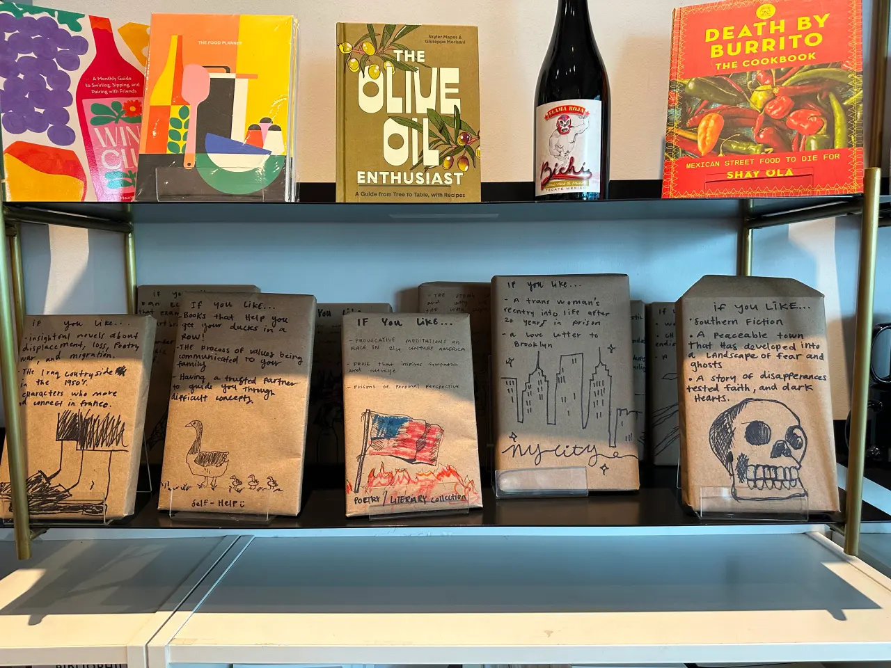 Photo of a book shelf with books and wine