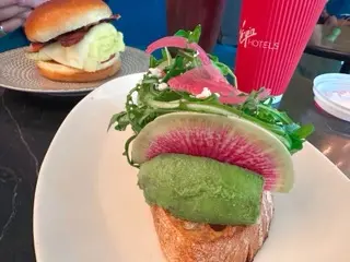 Avocado toast, breakfast sandwich, cappuccino, and iced Americano at Funny Library Coffee Shop