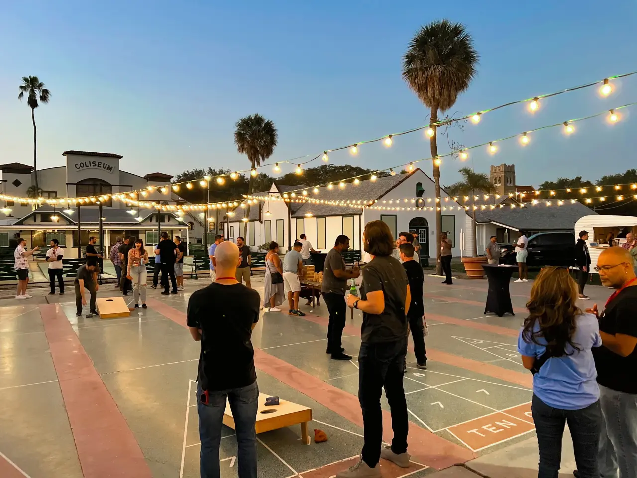 Photo of people playng cornhole at dusk