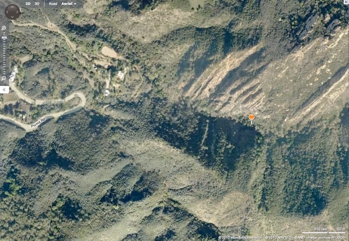 Aerial view of rugged canyon terrain near Piuma Road in Malibu, with a marker deep in the brush